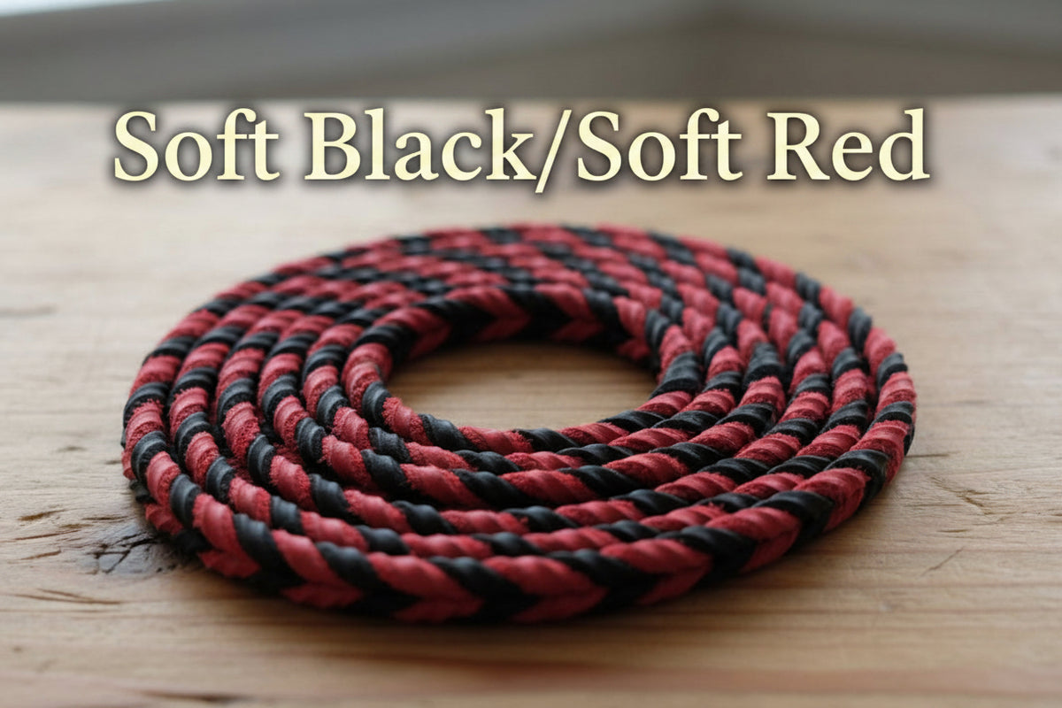 A coiled black and red braided rope or cord resting on a plain white surface.